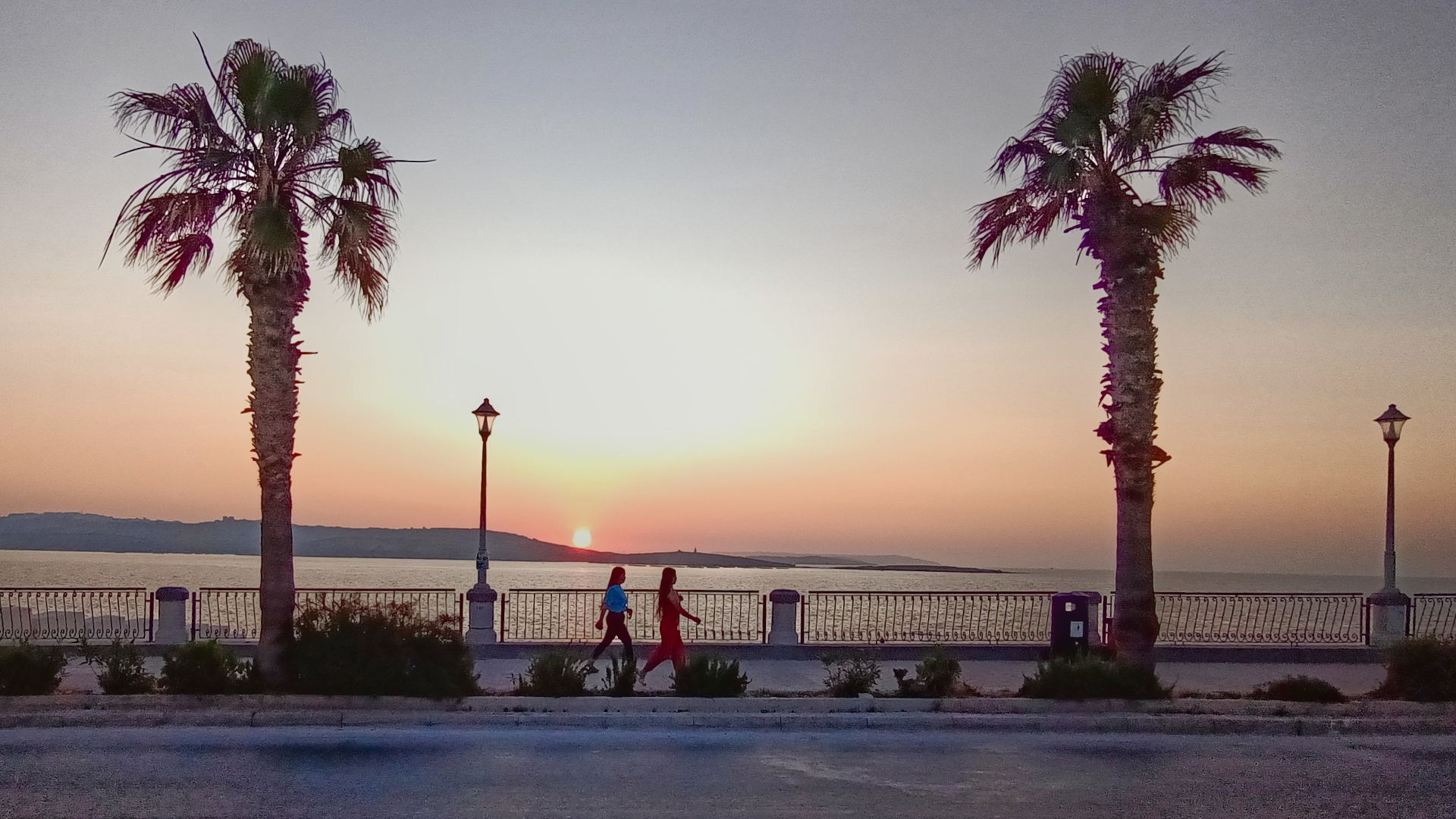 Zonsondergang op Malta - op de boulevard met uitzicht op zeer. Er lopen net 2 personen langs